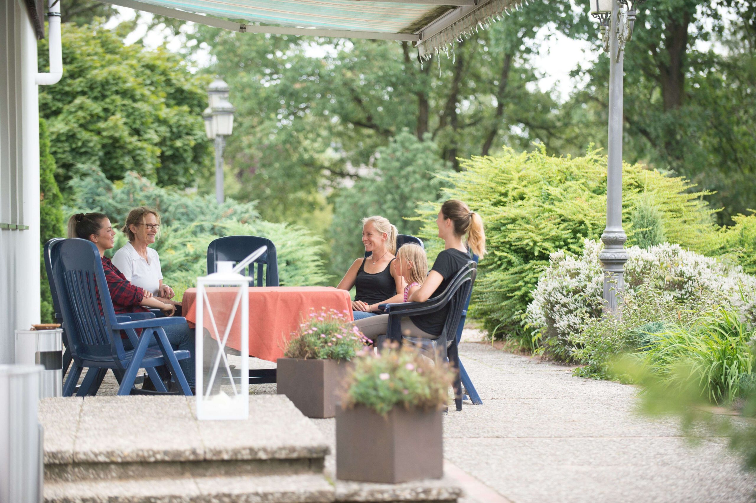 Eine Gruppe Menschen sitzt am Tisch und unterhält sich